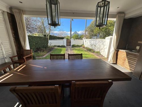 a dining room with a large wooden table and chairs at Wild Mushroom Country House in Stellenbosch
