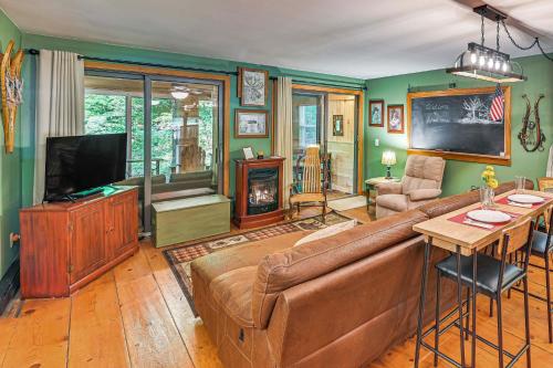 a living room with a couch and a television at Less Than 8 Mi to Gore Mountain! Family Cottage with Porch in Bakers Mills