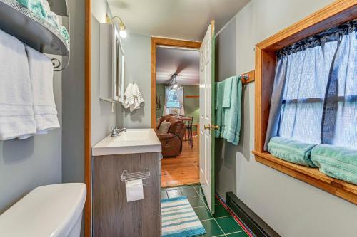 un bagno con lavandino, water e finestra di Cottage Less Than 8 Mi to Gore Mountain in Bakers Mill! a Bakers Mills