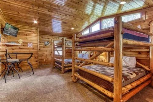 a log cabin with two bunk beds and a table at Day Dreamer Cabin W Views By Beyond Expectations in Gatlinburg