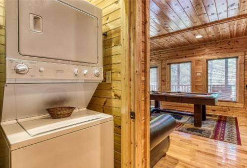 a kitchen with a washer and dryer in a log cabin at Day Dreamer Cabin W Views By Beyond Expectations in Gatlinburg