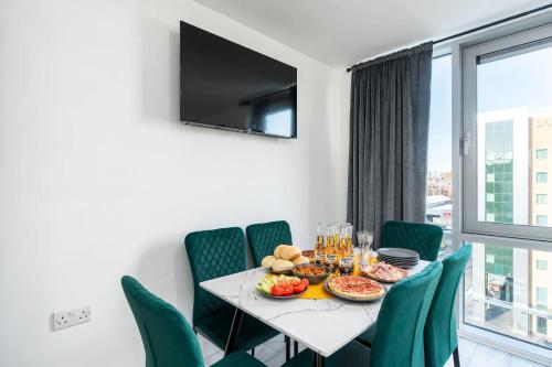 a dining room with a table and chairs and a window at 2 Bedroom 2 Bathroom Apartment with 5 Beds and Gated Parking near Sheffield United Stadium in Sheffield
