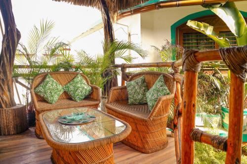 a patio with wicker chairs and a glass table at Monyoli Hotel & Boutique in Acapulco