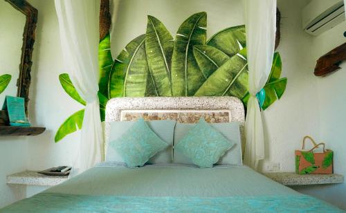 a bedroom with a bed with a large plant behind it at Monyoli Hotel & Boutique in Acapulco