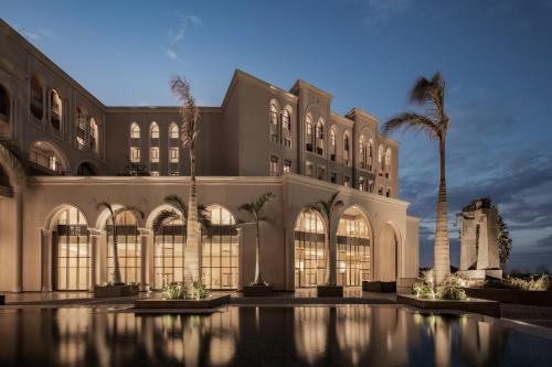 a large building with a pool in front of it at Giza Palace Hotel & Spa - The Leading Hotels Of The World in 6th Of October