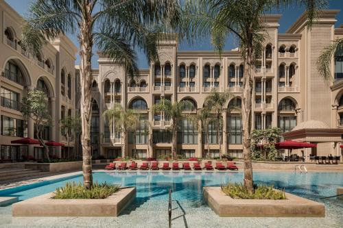a hotel with a swimming pool in front of a building at Giza Palace Hotel & Spa - The Leading Hotels Of The World in 6th Of October