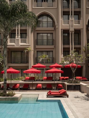 a hotel with red umbrellas and a swimming pool at Giza Palace Hotel & Spa - The Leading Hotels Of The World in 6th Of October