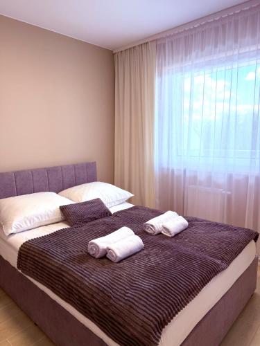 a bedroom with a large bed with two towels on it at LOFT APARTAMENT II Kępno in Kępno