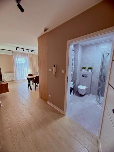 a bathroom with a shower and a toilet and a table at LOFT APARTAMENT II Kępno in Kępno