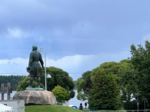 a statue of a man standing on a rock next to a river at Målkullorna Hostel in Mora