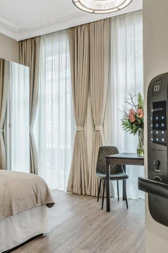 a bedroom with a bed and a table with a vase of flowers at Cleveland Residences Bloomsbury in London