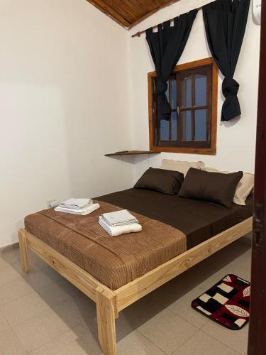 a bed with a wooden frame in a room at Dúplex cerca del Aeropuerto y Terminal de Ómnibus in Formosa