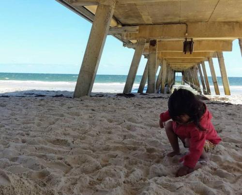 a little girl playing in the sand on the beach at No Stairs, Big House, Garage Richmond Residence 1 in West Richmond