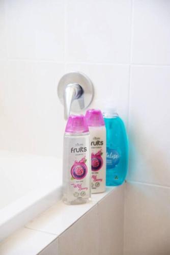 two bottles of milk sitting on a shelf in a bathroom at No Stairs, Big House, Garage Richmond Residence 1 in West Richmond
