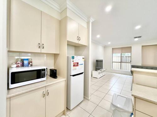 a kitchen with a microwave and a refrigerator at No Stairs, Big House, Garage Richmond Residence 1 in West Richmond