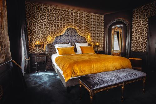 a bedroom with a large bed with a gold bedspread at Madame C - Hôtel très particulier in Strasbourg