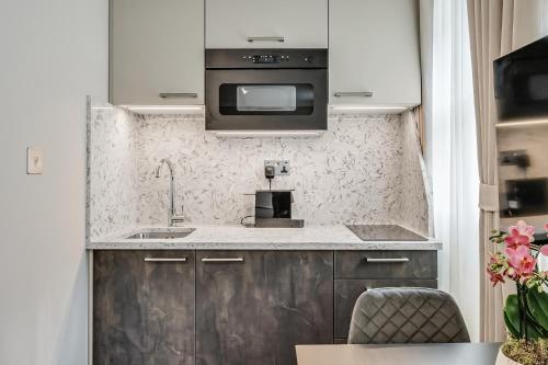 a kitchen with a sink and a microwave at Cleveland Residences Bloomsbury in London