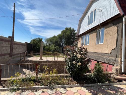 a house with a fence in front of it at Adventure Guest House in Pokrovka