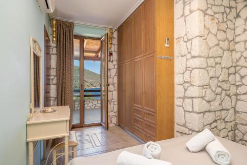 Habitación con cama, escritorio y puerta. en Luxury Stone Apartments, en Agia Efimia