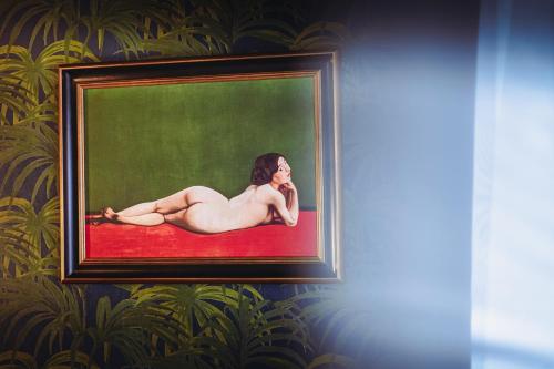 a painting of a woman laying on a red carpet at Madame C - Hôtel très particulier in Strasbourg