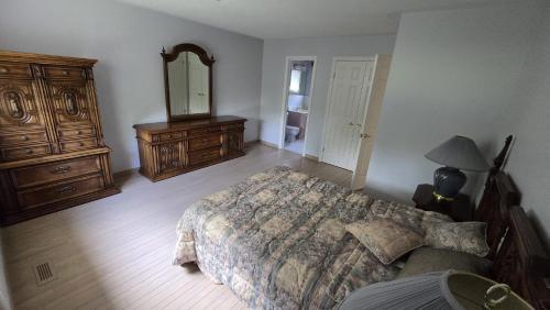 a bedroom with a bed and a dresser and a mirror at Spacious, Peaceful & Perfectly Located - 4BR,3BA in London