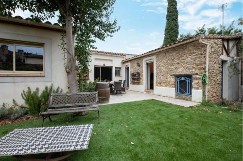 un jardin avec un banc et une maison dans l'établissement Atypical house with breathtaking city views, à Carcassonne