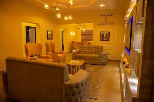 a living room with couches chairs and a television at Kf Apartments, Swimming pool, Gym, Wifi in Gwarinpa