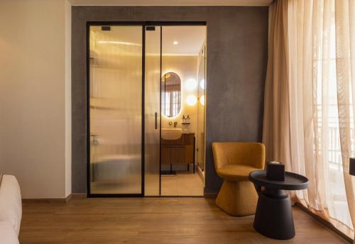 a room with a glass door and a yellow chair at Le Square By Onomo Collection in Casablanca