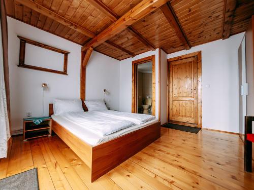 ein Schlafzimmer mit einem großen Bett und einer Holzdecke in der Unterkunft Casa din Zori in Muntele Băişorii