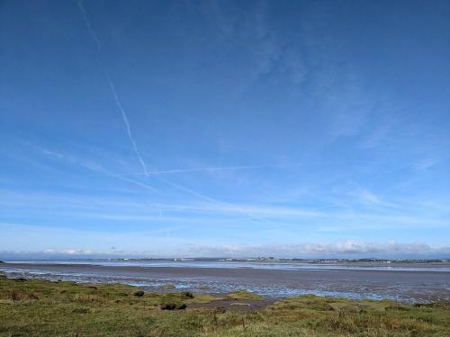 a kite flying in the sky over a body of water at Carlisle Cabin in Port Carlisle