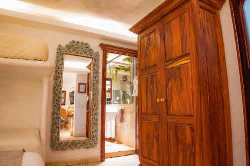 a bedroom with a wooden door and a mirror at Casa Jaguar Hotel & Boutique in Acapulco