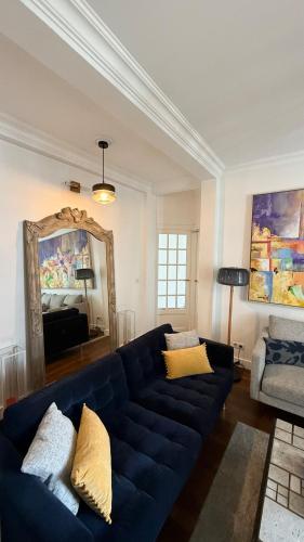 a living room with a blue couch and a mirror at Luxury et Comfort Apartment a Châtillon, Paris 5 min in Châtillon