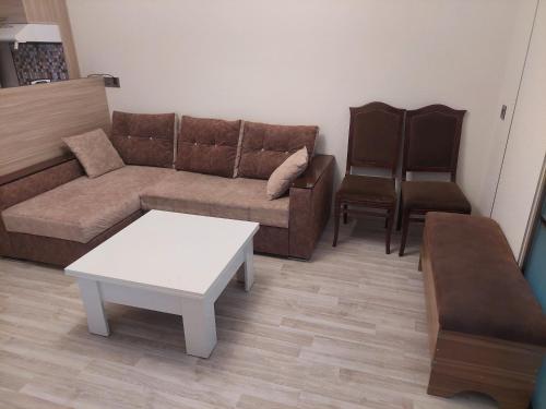 a living room with a couch and a coffee table at Двушка для гостей in Baku