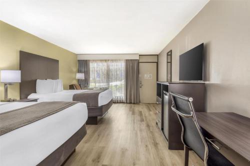 a hotel room with two beds and a flat screen tv at Best Western Asheville-Blue Ridge Parkway in Asheville