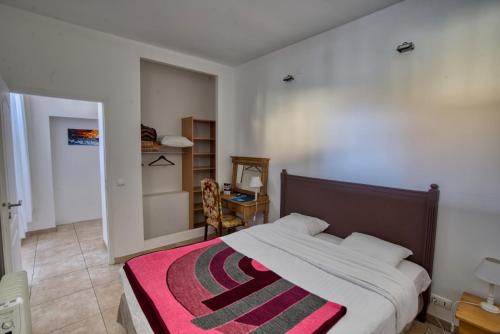 a bedroom with a bed with a red and black blanket at Domaine des Chais in Thénac