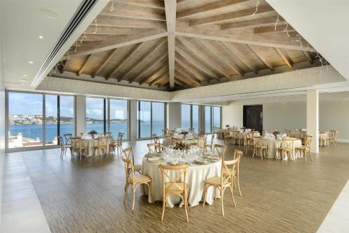 a banquet hall with white tables and chairs and windows at Barceló Illetas Albatros - Adults Only in Illetas
