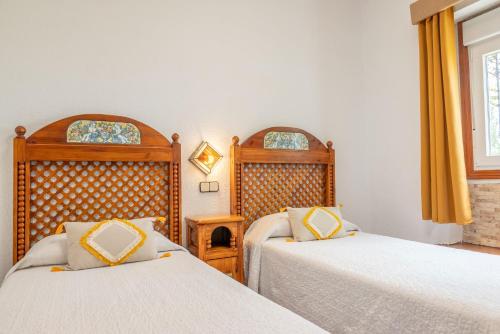 a bedroom with two beds and a window at Hotel Rural El Refugio in Tejeda