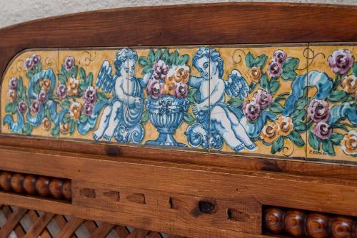 a wooden box with a painting of women and a vase at Hotel Rural El Refugio in Tejeda