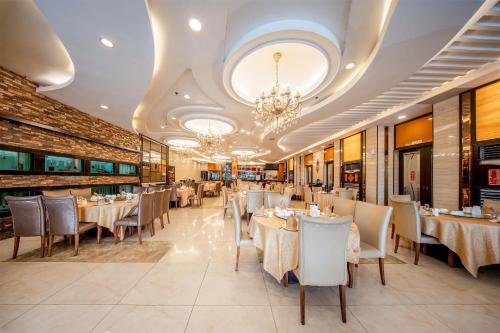 a restaurant with tables and chairs and a chandelier at Best Western Plus Hotel Subic in Olongapo