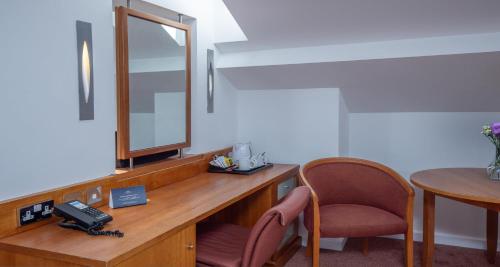 Zimmer mit einem Schreibtisch mit einem Spiegel und einem Stuhl in der Unterkunft Derby Mickleover Hotel, BW Signature Collection in Derby