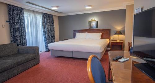 ein Hotelzimmer mit einem Bett und einer Couch in der Unterkunft Derby Mickleover Hotel, BW Signature Collection in Derby