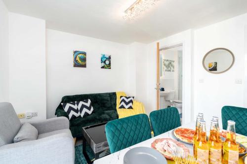 a living room with a table and green chairs at 2 Bedroom 2 Bathroom Apartment with 5 Beds and Gated Parking near Sheffield United Stadium in Sheffield