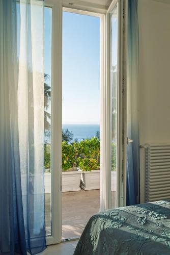 a bedroom with a sliding glass door with a view of the ocean at Maison Margot in Forio d'Ischia