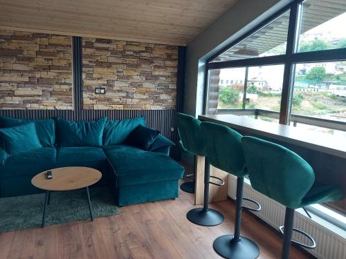 a living room with a green couch and chairs at Къща за гости Шанови in Gʼovren