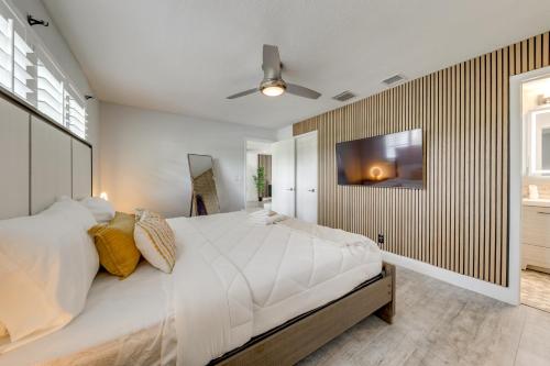 a bedroom with a large bed and a television on a wall at 5 Mi to Delray Public Beach Home with Large Patio! in Delray Beach