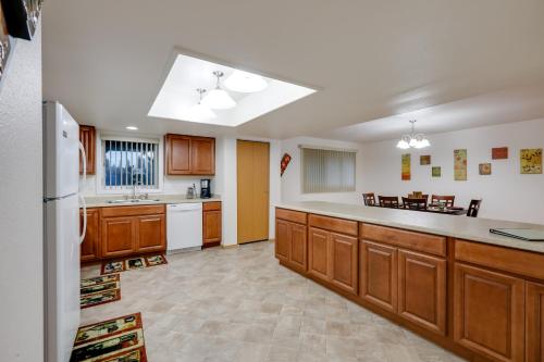 a large kitchen with wooden cabinets and white appliances at Fairbanks Alaskan Abode about 1 Mile to Pioneer Park! in Fairbanks