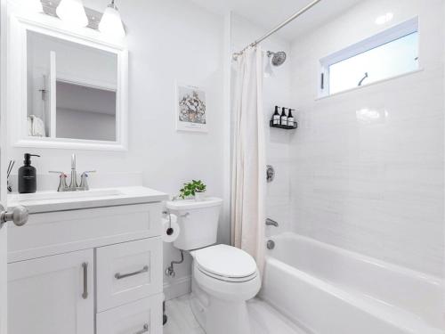 a white bathroom with a toilet and a sink at 4BR 3BATH Harvard MIT Home in Cambridge
