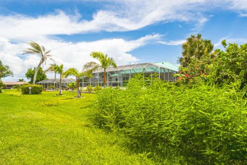 a building with palm trees in front of it at Golf Course-Facing Poolside Oasis in Rotunda West! in Rotonda West