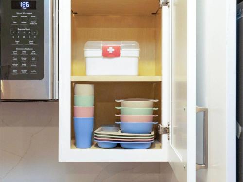 a kitchen cabinet with plates and bowls in it at 4BR 3BATH Harvard MIT Home in Cambridge