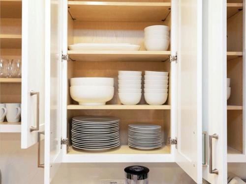 a cupboard filled with plates and bowls at 4BR 3BATH Harvard MIT Home in Cambridge